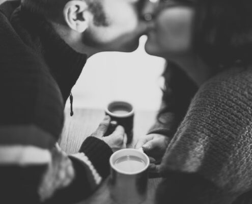 couple-kissing-over coffee